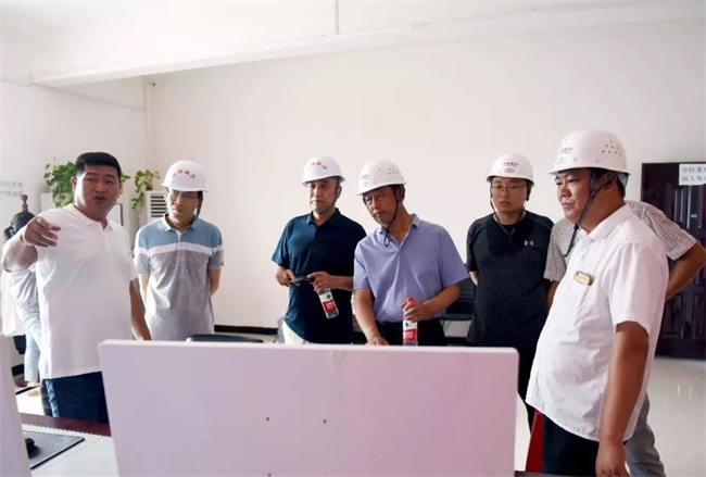 团队考察生产线上的中控室
